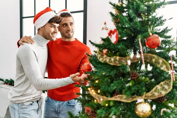 Two Hispanic Men Couple Hugging Each Other Decorating Christmas Tree — Stok fotoğraf