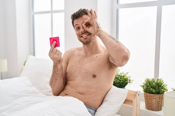 Joven Hombre Hispano Sosteniendo Condón Cama Sonriendo Feliz Haciendo Bien — Foto de Stock