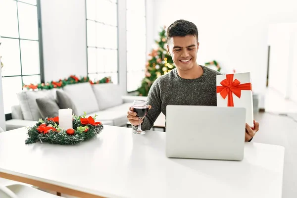 Young Hispanic Man Having Video Call Showing Gift Sitting Christmas — 스톡 사진