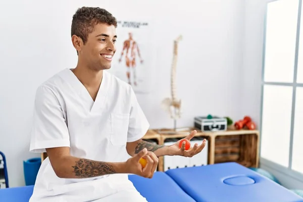 Young Hispanic Man Working Physiotherapist Holding Small Balls Physiotherapy Room — Stockfoto