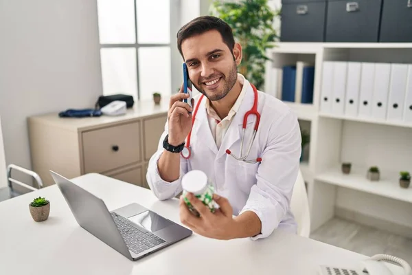 Doktor Üniforması Giyen Genç Spanyol Adam Klinikte Akıllı Telefonla Ilaç — Stok fotoğraf