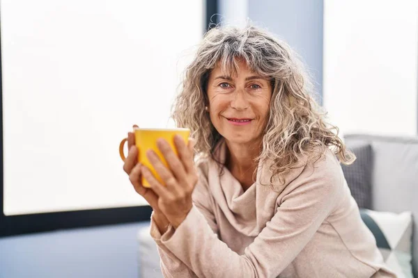 Middle Age Woman Drinking Coffee Sitting Sofa Home — стоковое фото