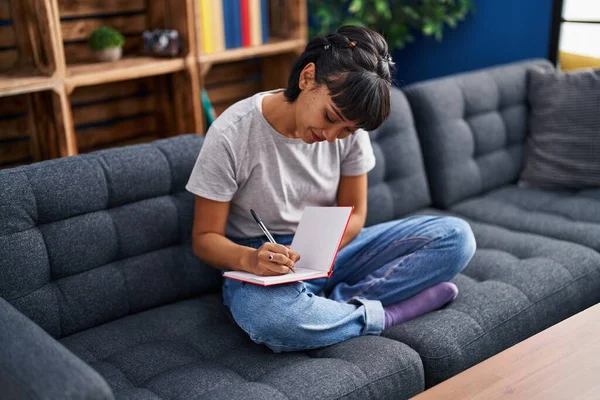 Mujer Joven Escribiendo Libro Sentado Sofá Casa —  Fotos de Stock