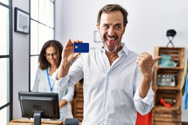 Hispanic Man Holding Credit Card Retail Shop Pointing Thumb Side — Fotografia de Stock
