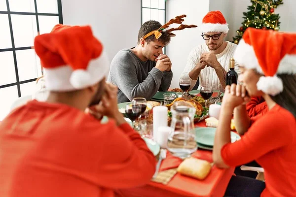 一群年轻人坐在家里的桌子上庆祝圣诞节 祈祷食物 — 图库照片