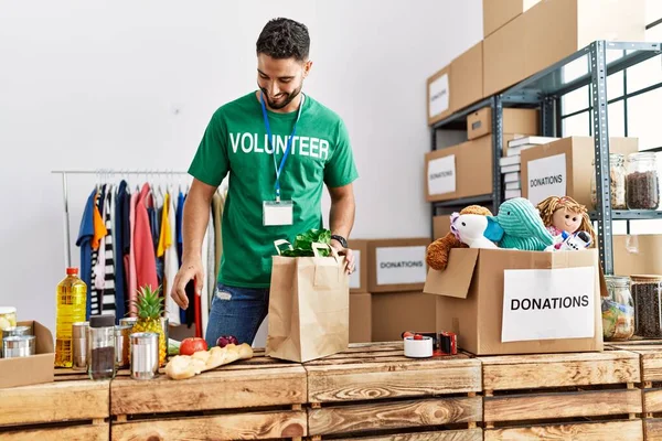 Gönüllü Üniformalı Genç Bir Arap Hayır Kurumunda Alışveriş Poşeti Hazırlıyor — Stok fotoğraf