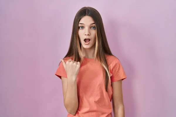 Teenager Girl Standing Pink Background Surprised Pointing Hand Finger Side — Photo
