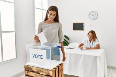 Anne ve kızı seçmen kurulunda kendine güvenen oylar vererek gülümsüyor.