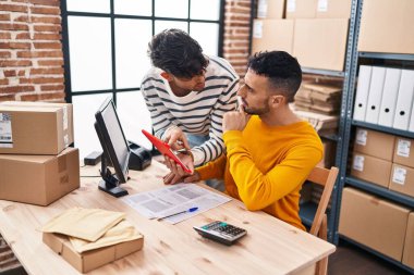 Two man ecommerce business workers using touchpad working at office