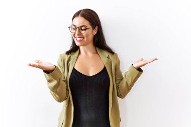 Young brunette woman standing over isolated background smiling showing both hands open palms, presenting and advertising comparison and balance 