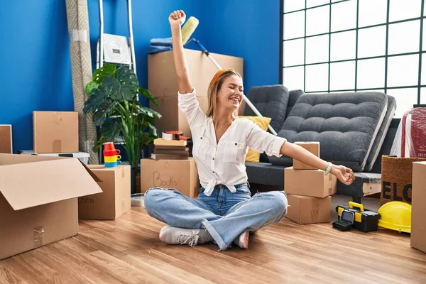 Young Hispanic Woman Sitting Floor Arms Open New Home — Stockfoto