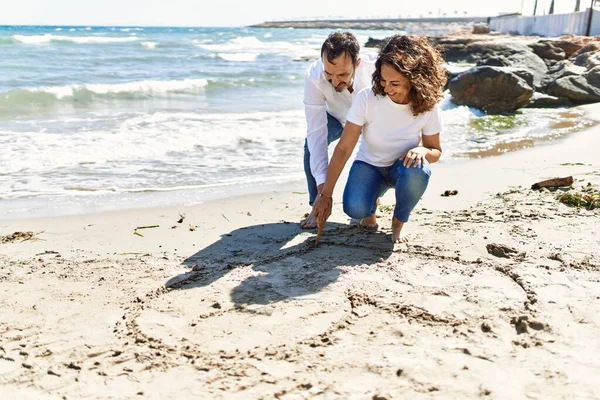 Casal Hispânico Meia Idade Sorrindo Coração Desenho Feliz Areia Praia — Fotografia de Stock