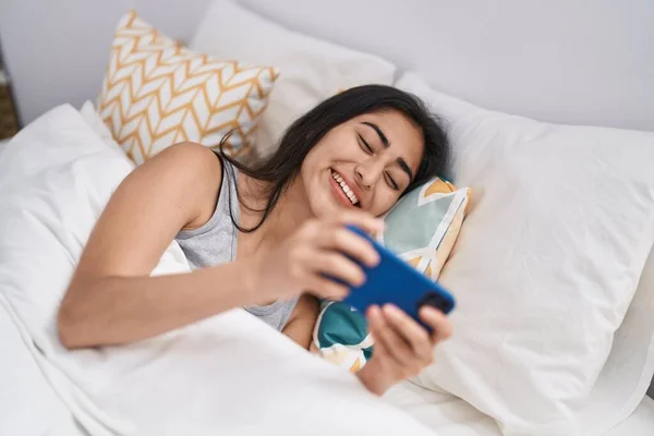 Young Hispanic Girl Using Smartphone Lying Bed Bedroom —  Fotos de Stock