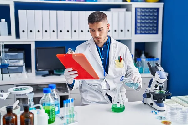 Joven Científico Hispano Midiendo Líquido Laboratorio — Foto de Stock