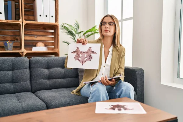 Young hispanic woman psychologist doing rorschach exam at psychology center