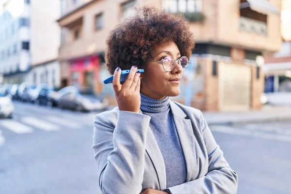アフリカ系アメリカ人女性エグゼクティブが路上でスマートフォンの音声メッセージを聞く — ストック写真