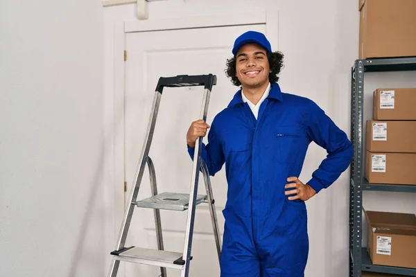 Young hispanic man technician holding ladder standing at office