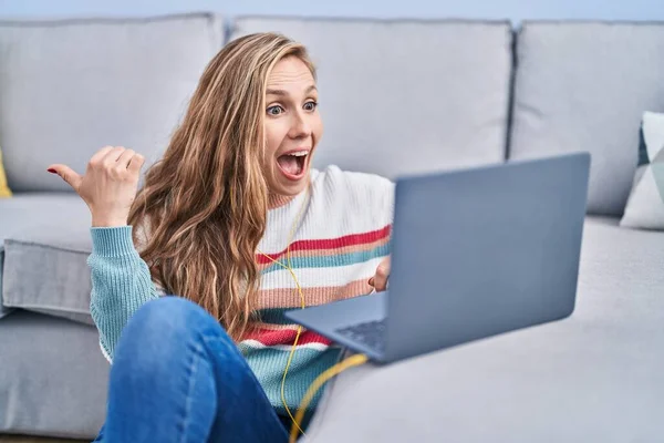 Genç Sarışın Kadın Evde Dizüstü Bilgisayar Kullanıyor Başparmağıyla Yan Tarafa — Stok fotoğraf