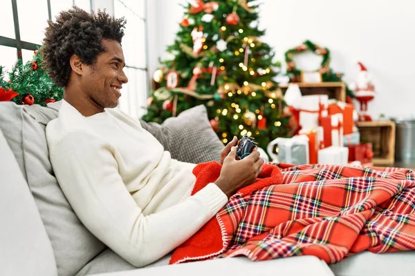 Joven Hombre Afroamericano Jugando Videojuego Sentado Sofá Por Árbol Navidad — Foto de Stock