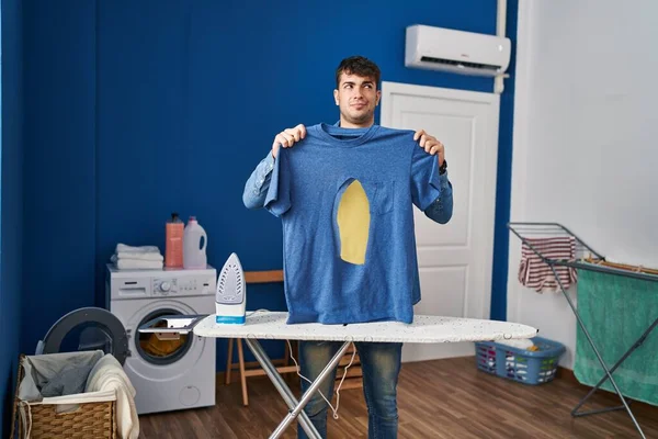 Joven Hombre Hispano Planchando Sosteniendo Camisa Hierro Quemada Lavandería Sonriendo — Foto de Stock