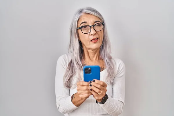 Kobieta Średnim Wieku Siwymi Włosami Pomocą Smartfona Wpisując Wiadomość Miga — Zdjęcie stockowe