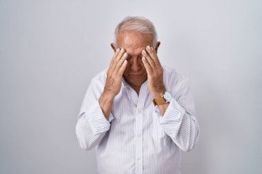 İzole edilmiş arka planda duran gri saçlı yaşlı bir adam. Ağlarken yüzünü ellerle kapatan üzgün bir ifade. depresyon kavramı. 