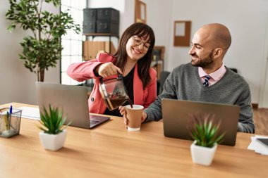 İki İspanyol iş adamı mutlu gülümsüyor. Ortağım ofiste kahve dolduruyor..