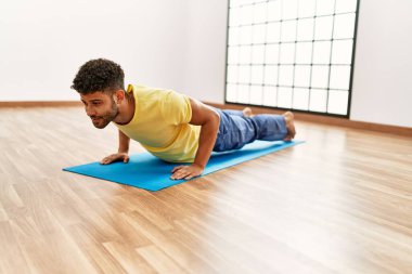 Genç Arap sporcu spor merkezinde karın kaslarını çalıştırmaya odaklan..