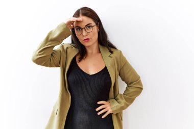 Genç esmer kadın izole edilmiş arka planda duruyor. Alnındaki bir sorun yüzünden endişeli ve stresli. Gergin ve bunalımda. 