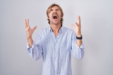 Beyaz arka planda beyaz bıyıklı beyaz bir adam çılgın ve kızgın bir şekilde bağırıyor ve agresif bir ifade ve kolla bağırıyor. hüsran kavramı. 