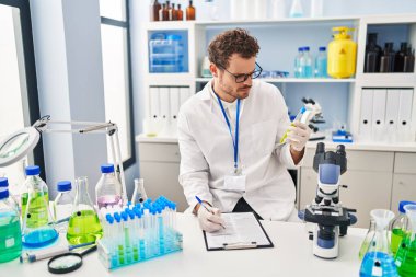 Laboratuvarda test tüpü tutan genç İspanyol bilim adamı.