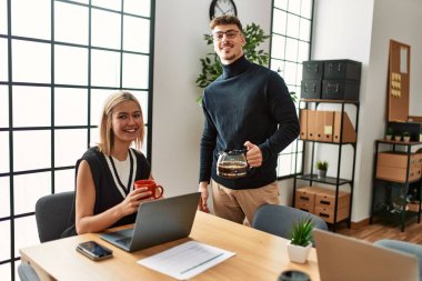 Ofiste çalışırken ve kahve içerken gülümseyen iki iş adamı..