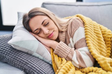 Young woman lying on sofa sleeping at home