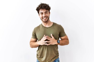 Hispanic man standing over isolated white background hands together and fingers crossed smiling relaxed and cheerful. success and optimistic 