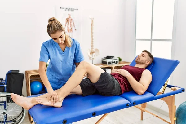 Young Hispanic Physioterapist Woman Make Ankle Rehab Treatment Man Clinic — Stock Photo, Image