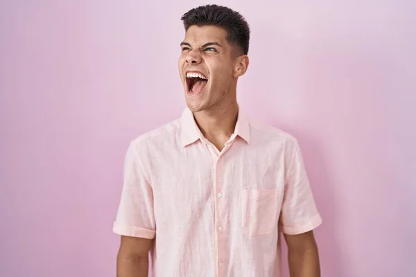 Молодий Іспаномовний Чоловік Стоїть Над Рожевим Тлом Сердитий Божевільний Кричить — стокове фото