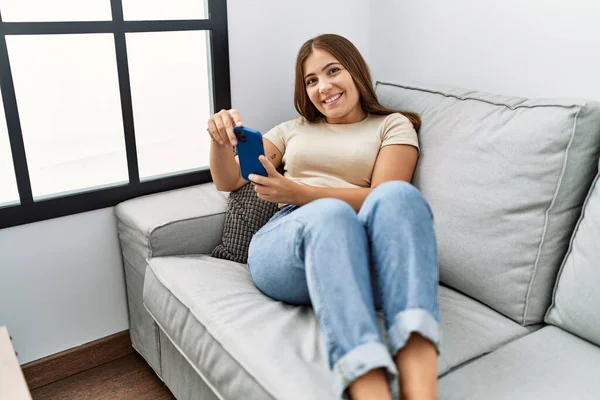 Genç Spanyol Kadın Evde Akıllı Telefon Kullanarak Gülümsüyor — Stok fotoğraf