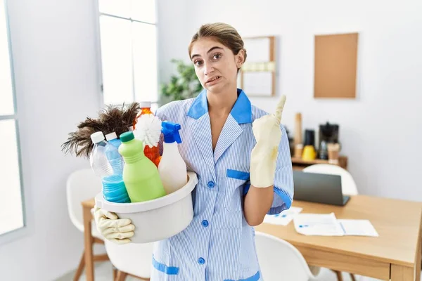 Giovane Donna Bionda Indossa Detergente Uniforme Tenuta Prodotti Pulizia Indicando — Foto Stock