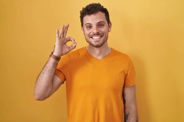 Homem Hispânico Jovem Sobre Fundo Amarelo Sorrindo Positivo Fazendo Sinal — Fotografia de Stock