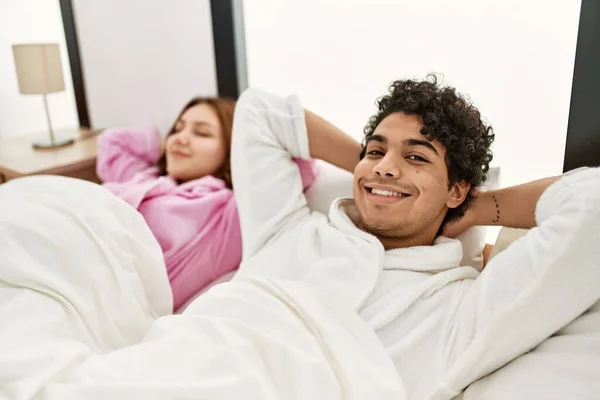 Молода Пара Посміхається Щаслива Розслаблена Руками Голові Лежить Ліжку Спальні — стокове фото