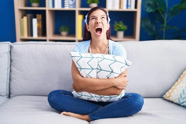 Junge Hispanische Frau Umarmt Kissen Auf Dem Sofa Sitzend Wütend — Stockfoto