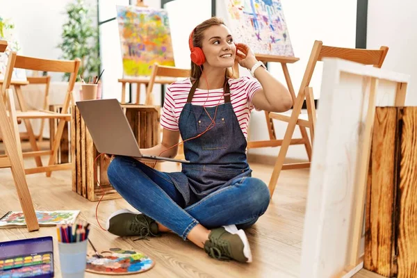 Ung Kvinde Smilende Selvsikker Ved Hjælp Bærbare Hovedtelefoner Kunststudiet - Stock-foto