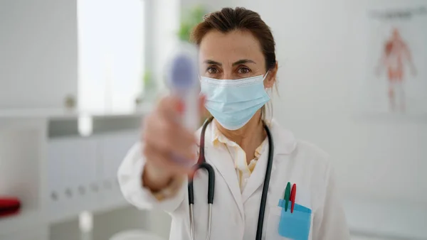 Klinikte Termometre Kullanan Orta Yaşlı Spanyol Kadın Doktor Üniforması Tıbbi — Stok fotoğraf