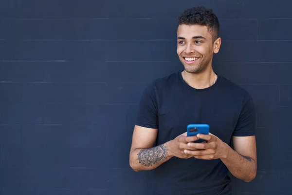 Afrikanischer Mann Lächelt Selbstbewusst Mit Smartphone Vor Schwarzem Hintergrund — Stockfoto