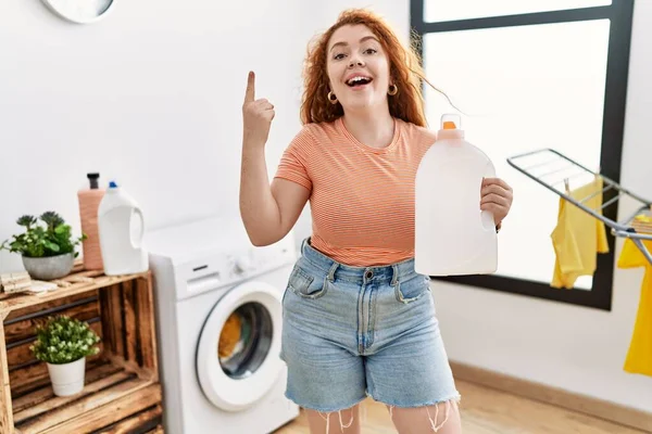 Young Redhead Woman Doing Laundry Holding Detergent Bottle Smiling Idea — Stock Photo, Image