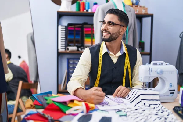 在服装厂 年轻的阿拉伯男子裁缝师自信地在笔记本上画画 — 图库照片