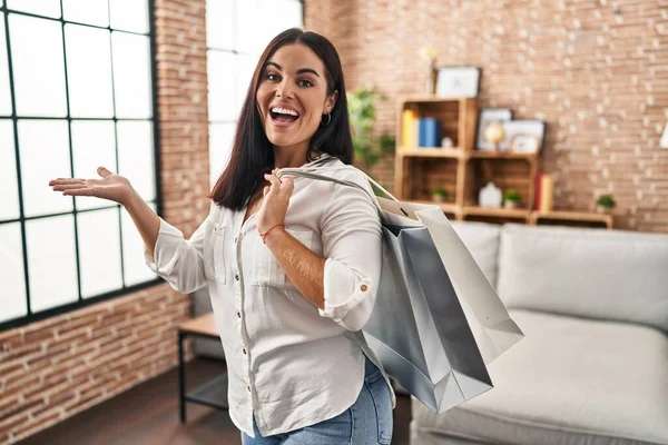 Ung Latinamerikansk Kvinna Håller Shoppingväskor Firar Prestation Med Glada Leende — Stockfoto