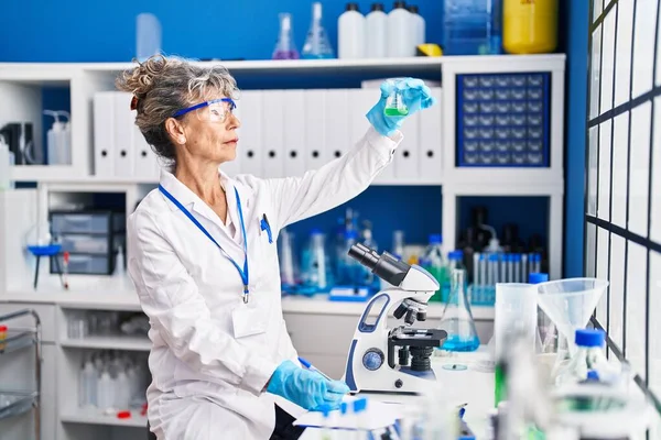Kobieta Średnim Wieku Naukowiec Trzyma Probówkę Napisać Schowku Laboratorium — Zdjęcie stockowe