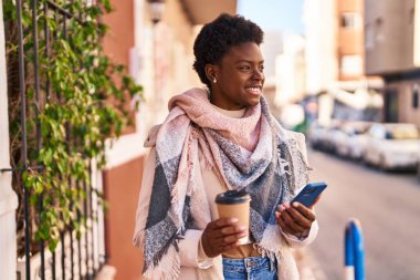 Sokakta kahve içen Afro-Amerikan kadın.