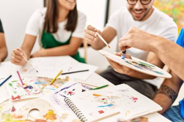 Resim stüdyosunda çizim yapan bir grup insan..